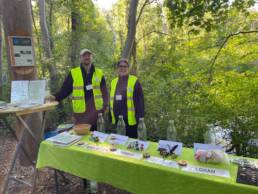 Zwei aus dem Infoteam vor dem Infostand im Wald